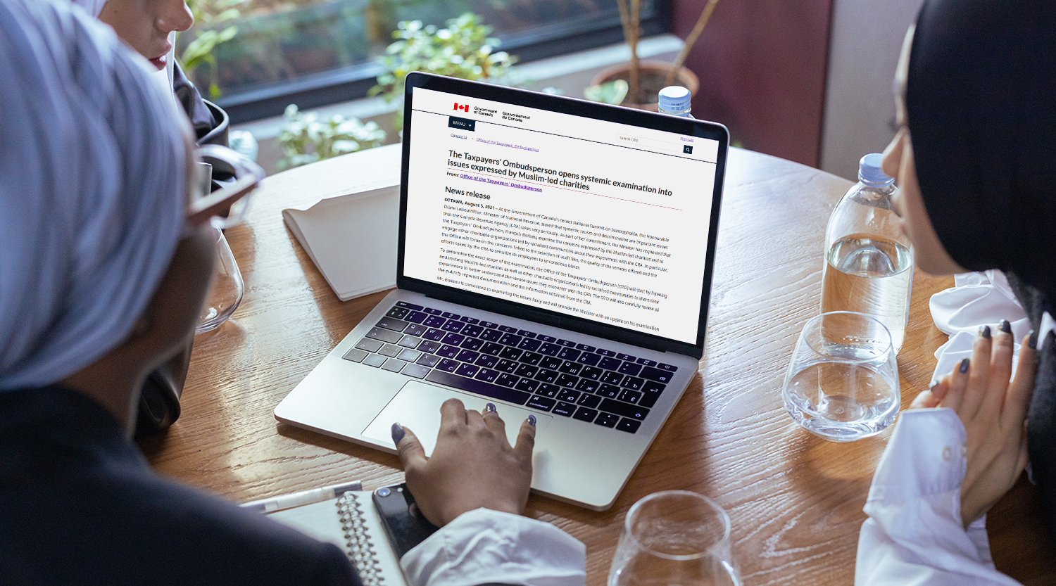 Three women looking at laptop with news release 